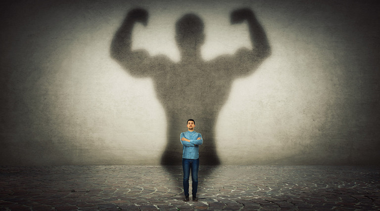 man in bright light with harms up