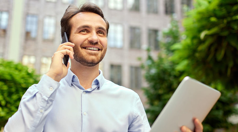 Person working outside on tablet and phone